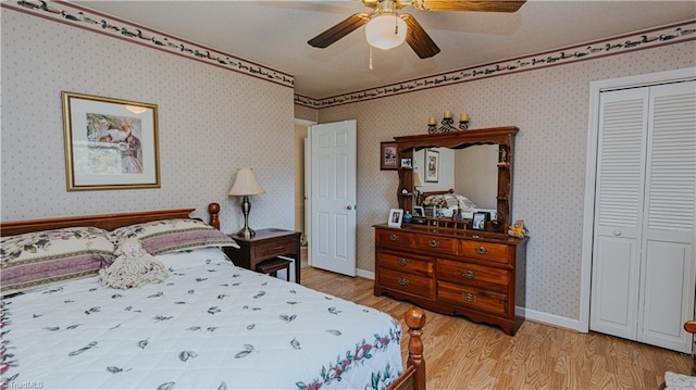 bedroom with ceiling fan, light hardwood / wood-style floors, and a closet