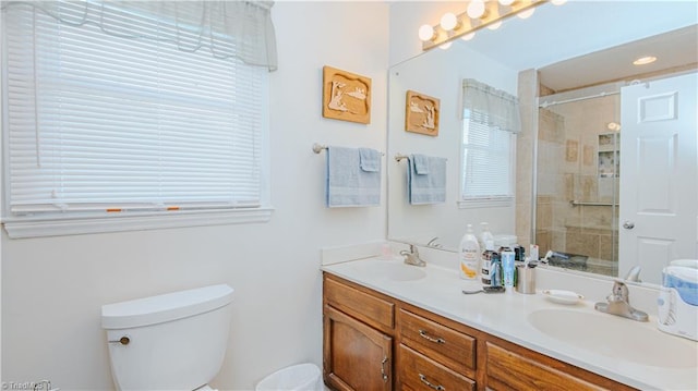 bathroom with vanity, toilet, and a shower with door