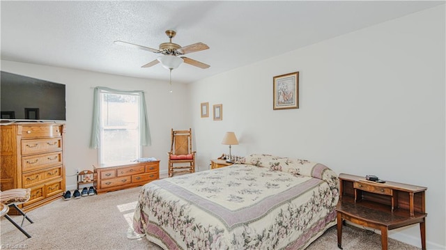 carpeted bedroom with ceiling fan and a textured ceiling