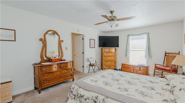 carpeted bedroom with ceiling fan and a textured ceiling