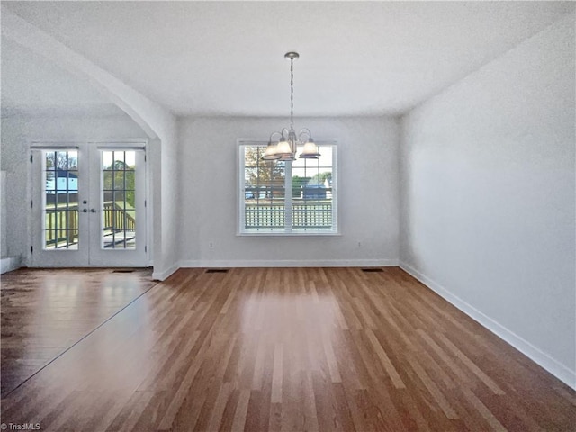 unfurnished dining area with hardwood / wood-style floors, a healthy amount of sunlight, and french doors