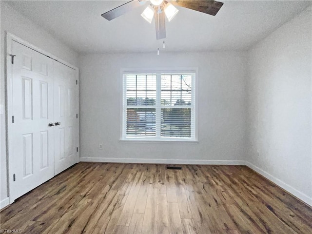 unfurnished bedroom with a closet, wood-type flooring, ceiling fan, and a textured ceiling