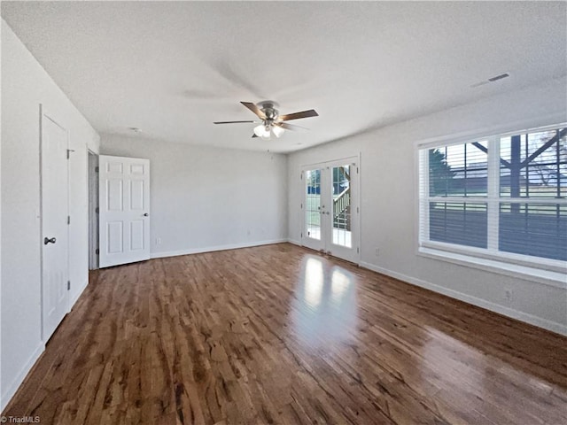 empty room with dark wood-type flooring, french doors, ceiling fan, and a textured ceiling