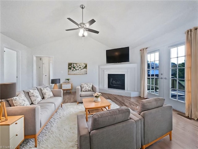 living room with french doors, light hardwood / wood-style floors, ceiling fan, and lofted ceiling