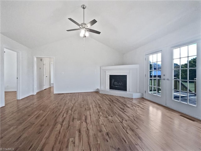 unfurnished living room featuring french doors, hardwood / wood-style flooring, ceiling fan, and vaulted ceiling