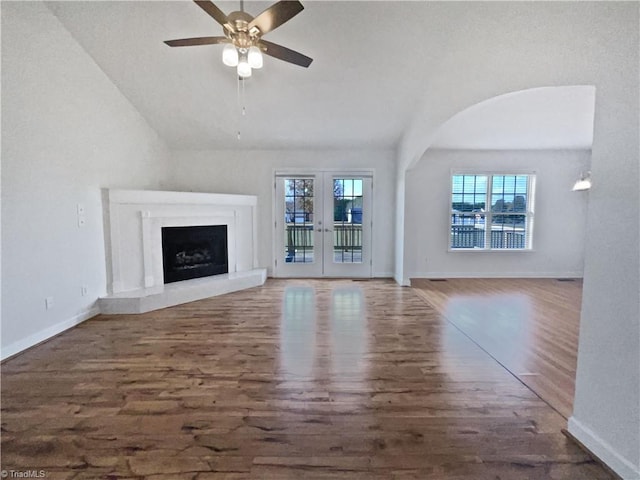 unfurnished living room featuring french doors, dark wood-type flooring, ceiling fan, and lofted ceiling