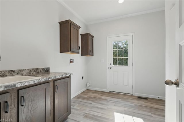 2875 Motsinger Rd, Winston-Salem, NC 27107 - washroom featuring electric dryer hookup, ornamental molding, light wood-type flooring, hookup for a washing machine, and cabinet space