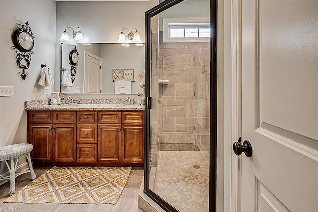 bathroom featuring a shower with door, vanity, and hardwood / wood-style floors