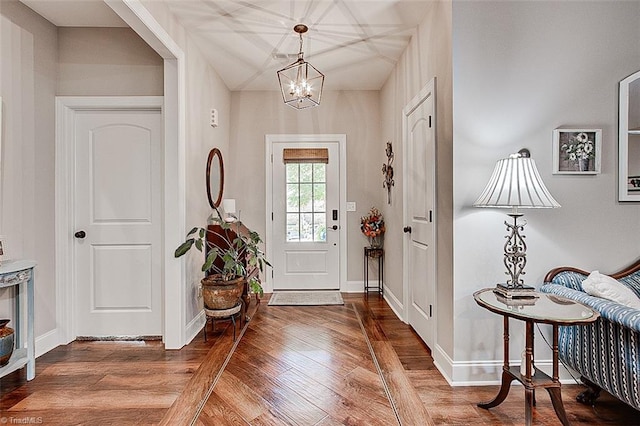 foyer entrance featuring hardwood / wood-style flooring and a notable chandelier