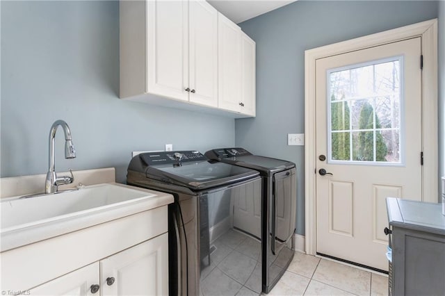 washroom featuring separate washer and dryer, light tile patterned floors, cabinet space, and a sink