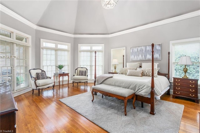 bedroom with ornamental molding, high vaulted ceiling, and wood finished floors