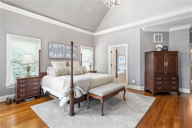 bedroom featuring visible vents, high vaulted ceiling, wood finished floors, connected bathroom, and baseboards