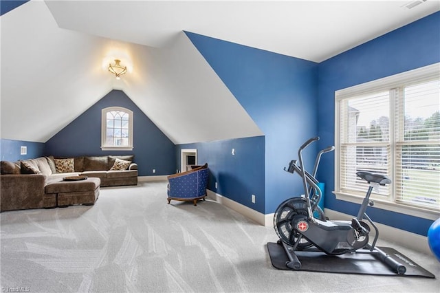 workout area with carpet flooring, baseboards, and vaulted ceiling