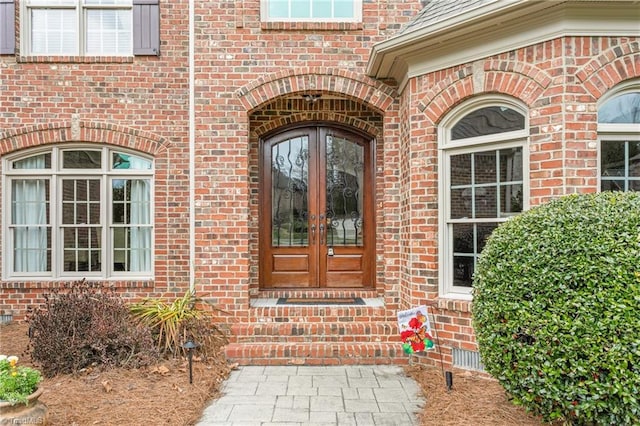 property entrance with french doors and brick siding