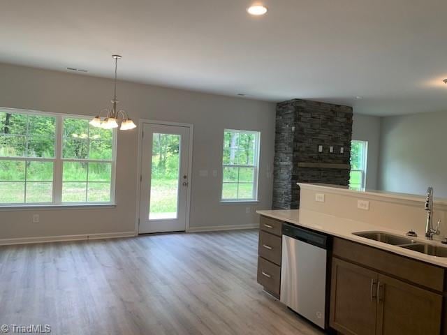 kitchen with dishwasher, a healthy amount of sunlight, sink, and light hardwood / wood-style flooring