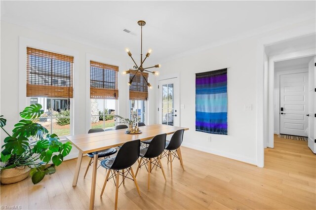 dining room with baseboards, visible vents, light wood-style floors, and a chandelier