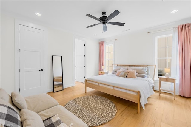 bedroom featuring a ceiling fan, baseboards, recessed lighting, and light wood-style floors