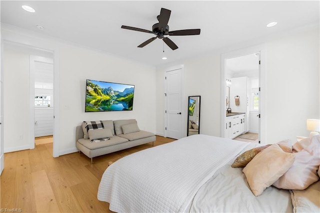 bedroom with light wood finished floors, ensuite bathroom, baseboards, and recessed lighting