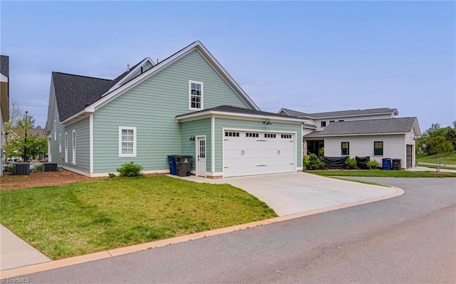 view of front of property with a front lawn, driveway, central AC unit, and a garage