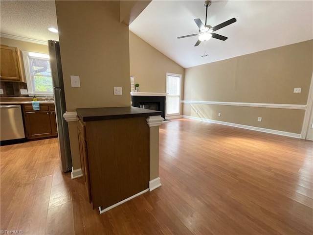 kitchen featuring stainless steel appliances, ceiling fan, a textured ceiling, light hardwood / wood-style flooring, and lofted ceiling