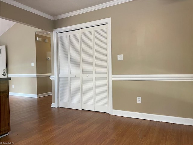 unfurnished bedroom featuring ornamental molding, dark hardwood / wood-style flooring, and a closet