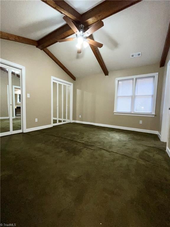 unfurnished living room featuring ceiling fan, vaulted ceiling with beams, and dark carpet