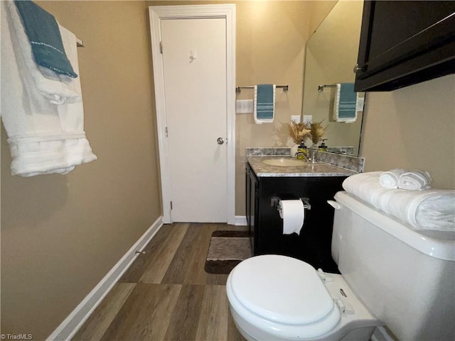 bathroom featuring wood-type flooring, vanity, and toilet