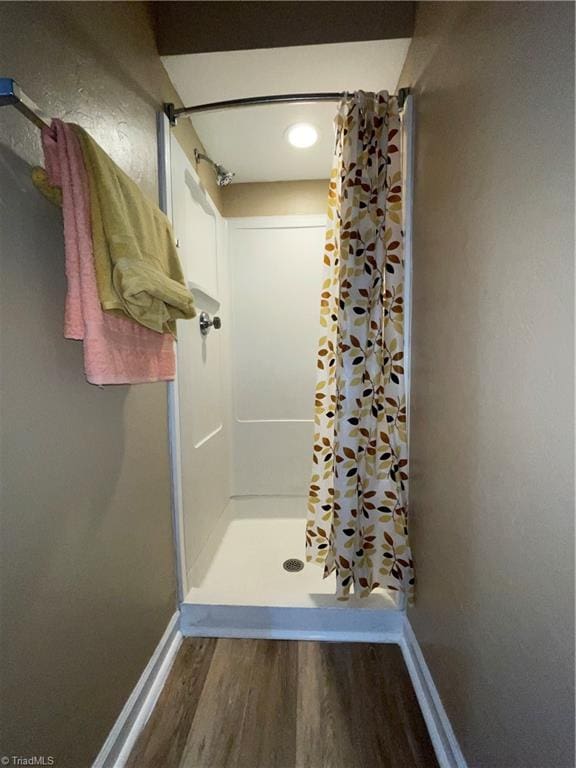 bathroom featuring wood-type flooring and a shower with curtain