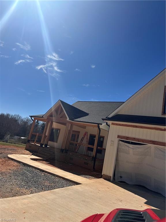 view of front of house featuring an attached garage and a porch