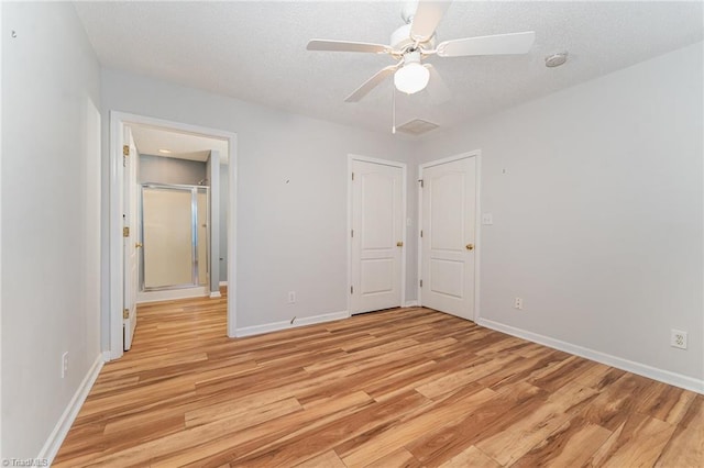 unfurnished bedroom with baseboards, ceiling fan, light wood-style flooring, and a textured ceiling