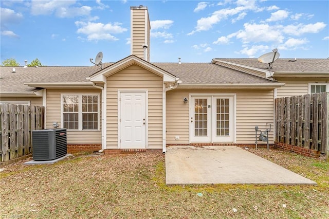 back of property featuring a patio area, a chimney, fence, and central AC unit