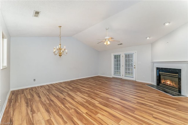 unfurnished living room with lofted ceiling, visible vents, light wood-style flooring, a premium fireplace, and baseboards