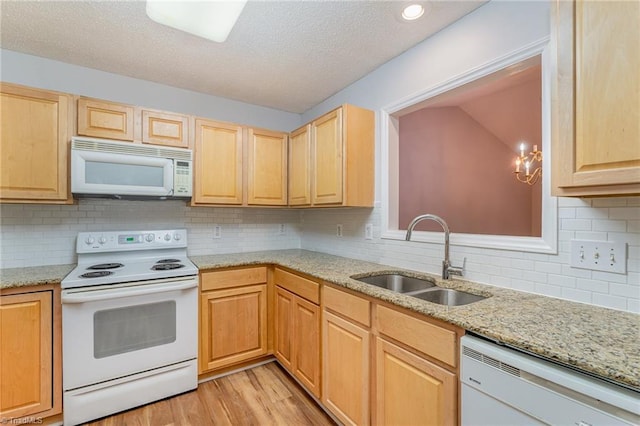 kitchen featuring white appliances, light stone countertops, light wood-style floors, light brown cabinets, and a sink