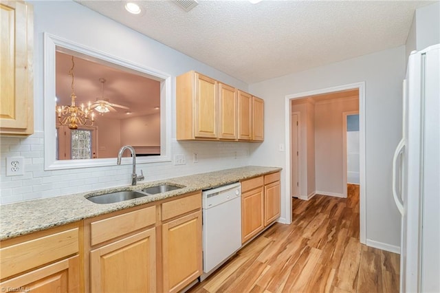 kitchen with backsplash, light wood-style floors, light brown cabinets, a sink, and white appliances