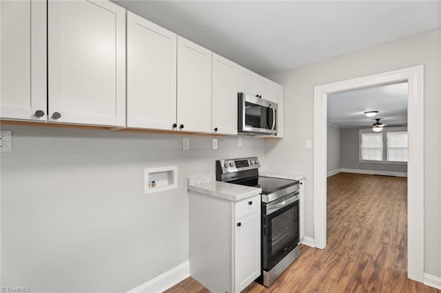 2505 Druid Hills Dr, Winston-Salem, NC 27105 - kitchen with stainless steel appliances, light countertops, wood finished floors, white cabinets, and ceiling fan