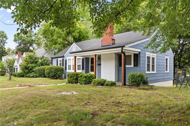 2505 Druid Hills Dr, Winston-Salem, NC 27105 - view of front of property featuring a front lawn, a chimney, covered porch, and roof with shingles