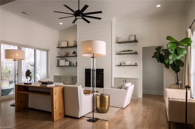 living room featuring ornamental molding, wood finished floors, recessed lighting, a fireplace, and ceiling fan