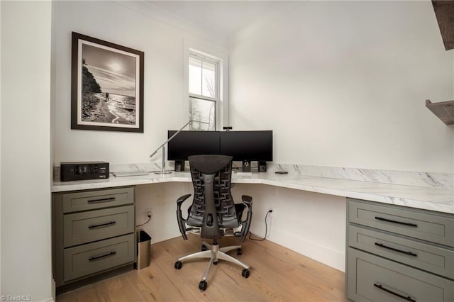 home office featuring light wood-type flooring and built in study area