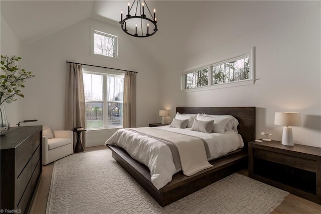 bedroom featuring high vaulted ceiling and an inviting chandelier