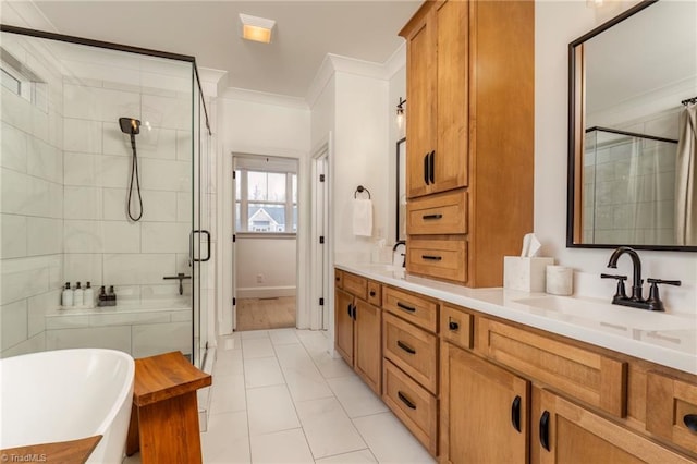 bathroom featuring ornamental molding, a stall shower, a freestanding bath, and a sink