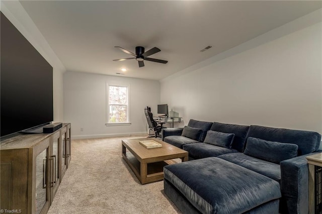 living area featuring light carpet, visible vents, baseboards, and a ceiling fan