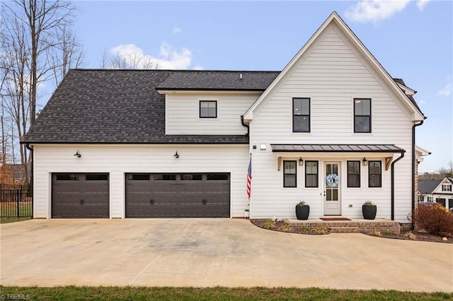 modern inspired farmhouse with fence, driveway, and roof with shingles