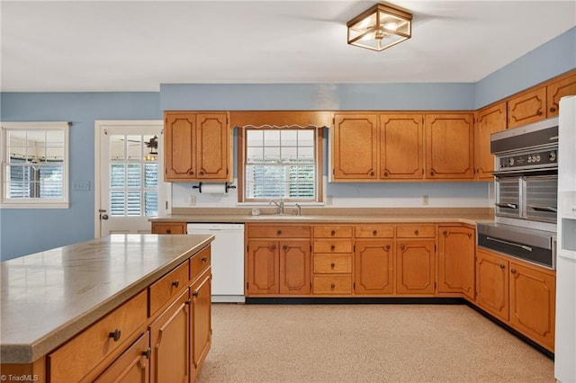 1409 Coventry Rd, High Point, NC 27262 - kitchen with white dishwasher, a warming drawer, brown cabinets, light countertops, and stainless steel oven