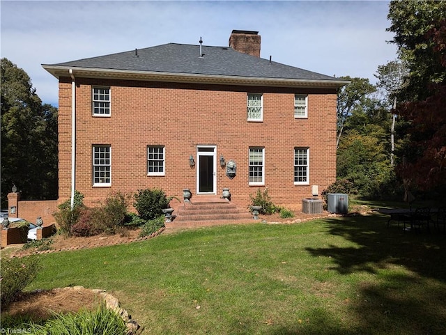 rear view of house featuring a yard and central air condition unit