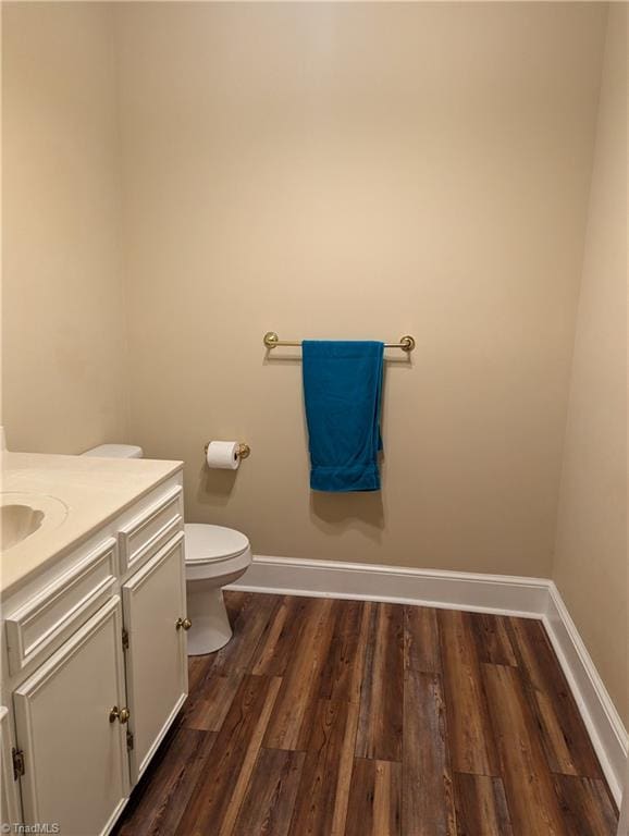 bathroom with toilet, hardwood / wood-style flooring, and vanity