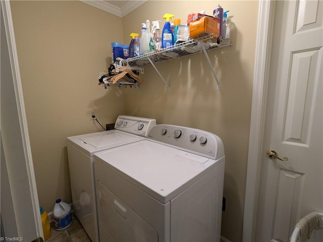 washroom with tile patterned floors, ornamental molding, and washing machine and clothes dryer