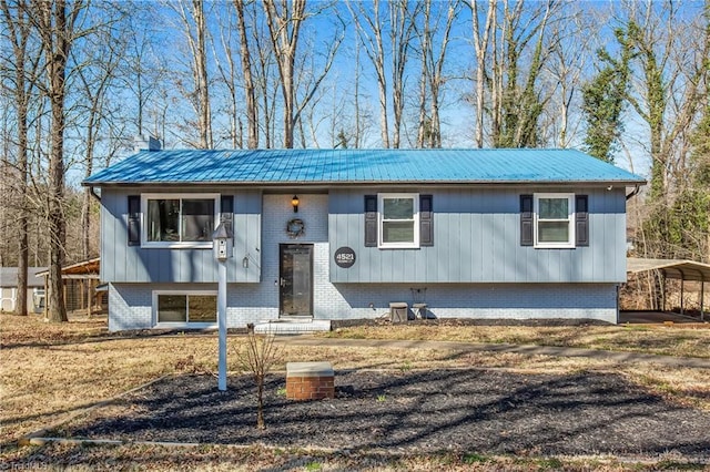 split foyer home with metal roof and brick siding