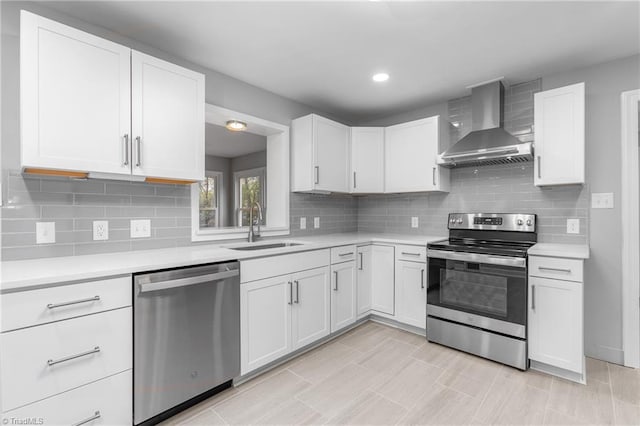 kitchen featuring white cabinets, wall chimney exhaust hood, and appliances with stainless steel finishes