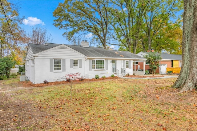 single story home featuring central AC unit, a garage, and a front yard