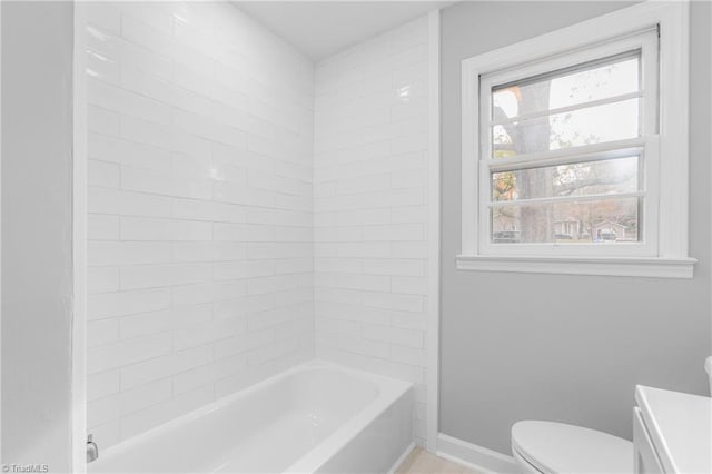 full bathroom featuring vanity, tiled shower / bath combo, and toilet